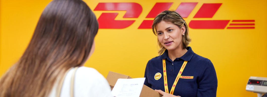 Female handing over a shipment to DHL Express officer at a DHL Express outlet