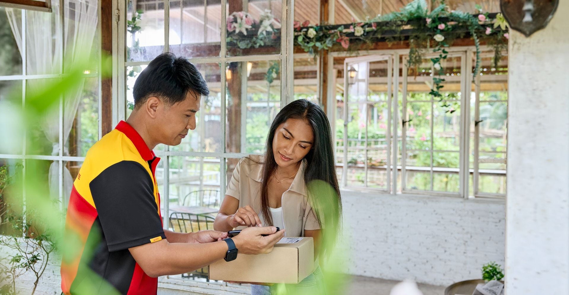 a customer and DHL employee check the DHL Express air waybill