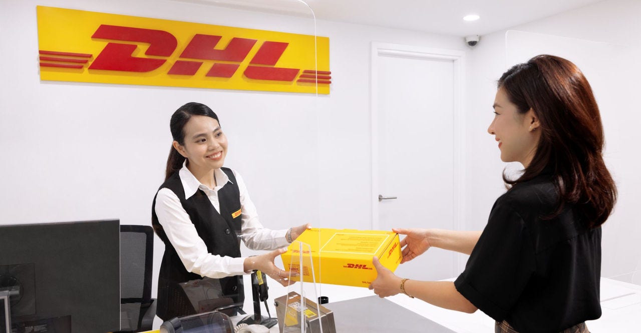 customer with shipping package being passed to a dhl express service centre