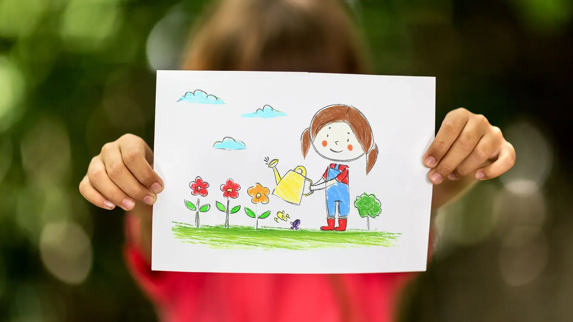 child holding up a drawing