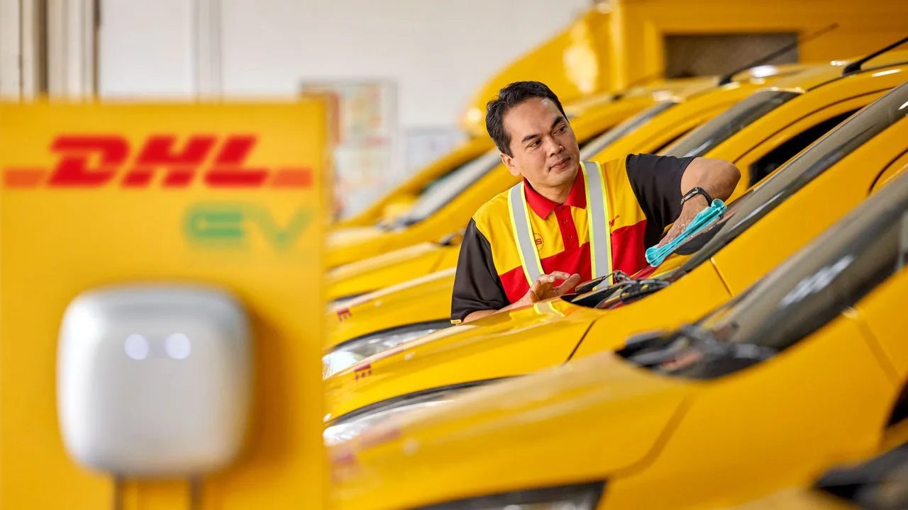 DHL courier cleaning an EV van