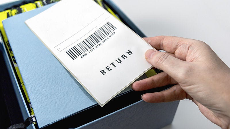 Hand holding a return label over a blue box