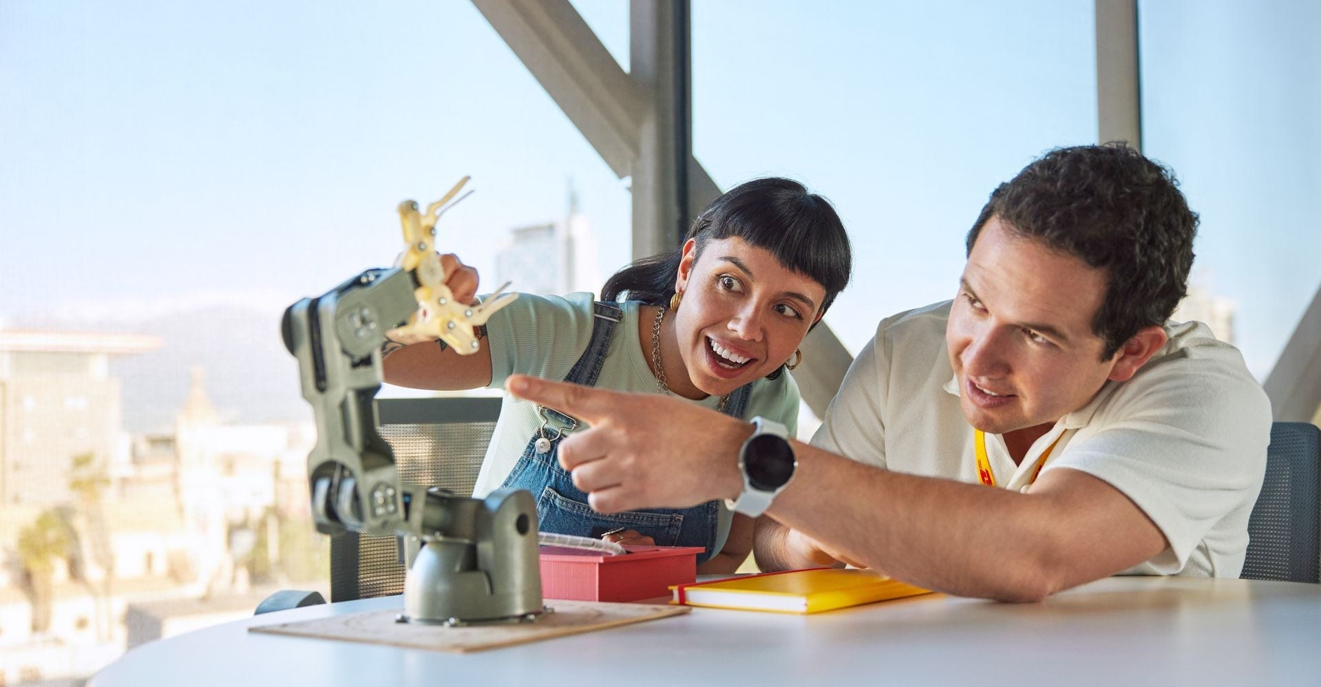 dhl employees examining a robotic arm