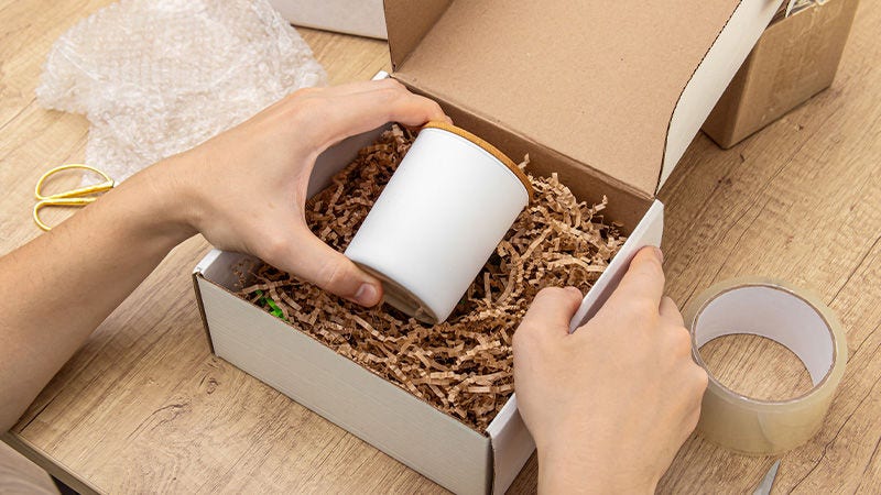 Man packing a fragile item with cushioning inside a box