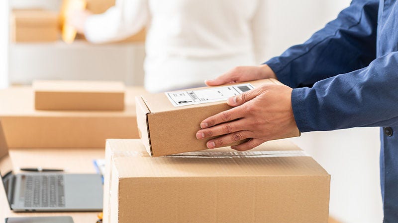 Entrepreneur sealing a box with tape before labelling the shipment