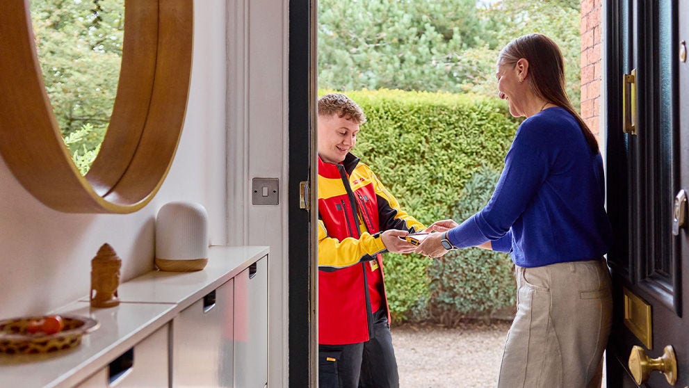 dhl courier handing parcel to a woman in a blue blouse