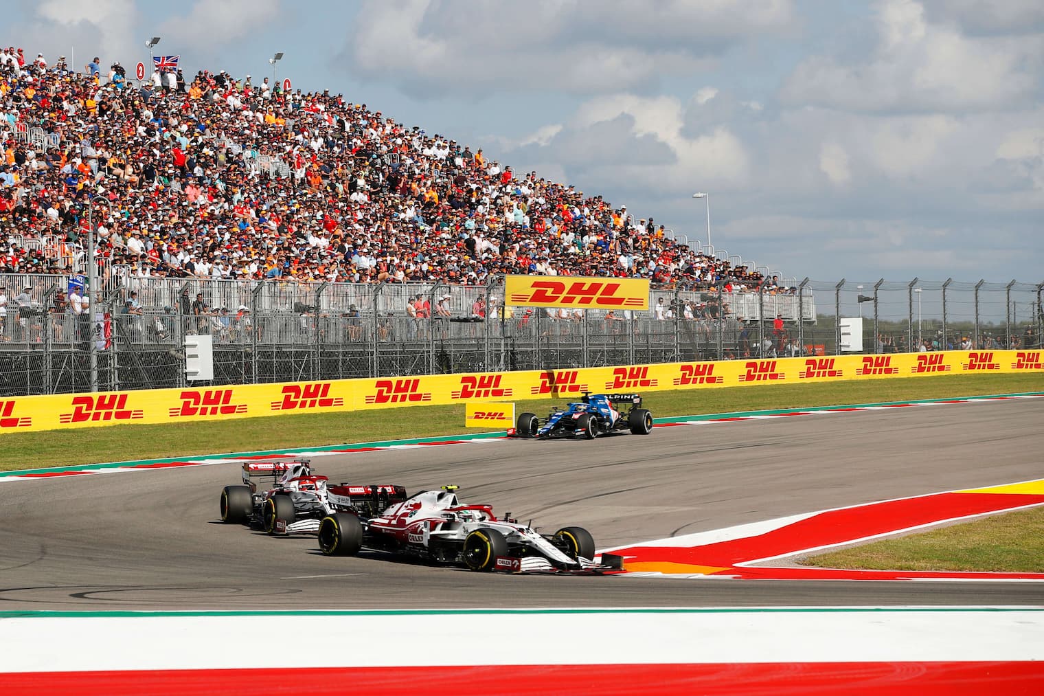 F1 track and cheering fans Racers drive around the track as the crowd cheers