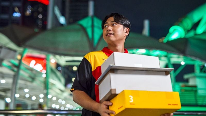 dhl express courier holding multiple parcels