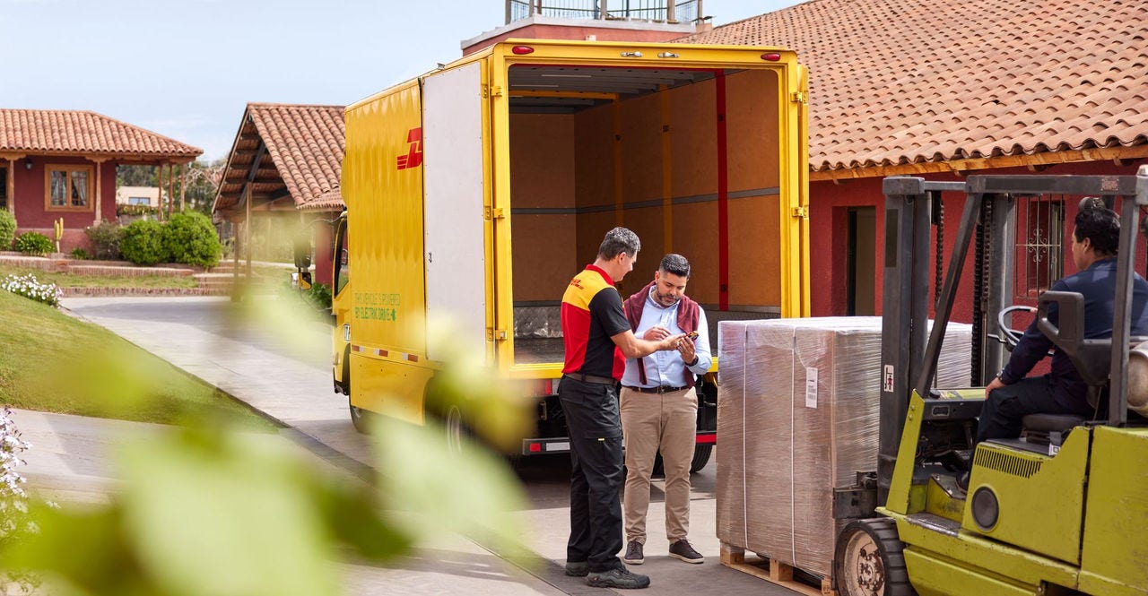 A DHL employee delivering a heavy-weight package to a client.