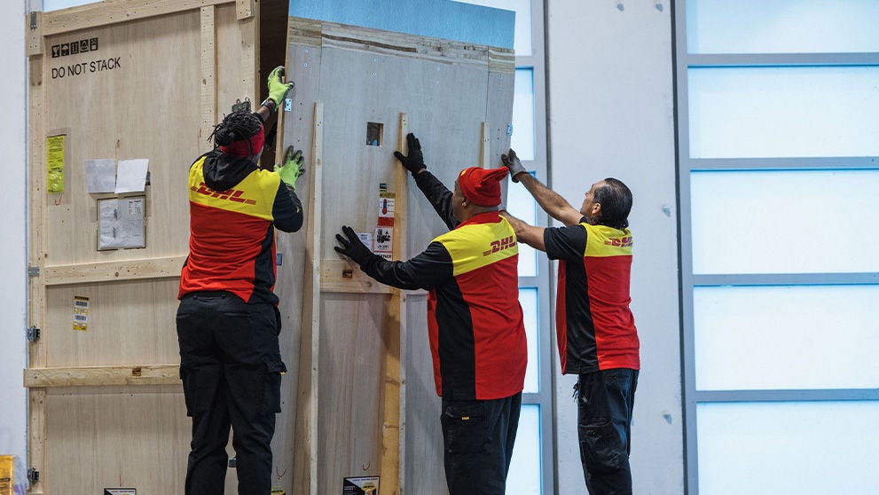 three DHL employees closing storage container