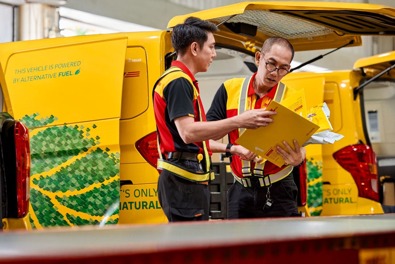 two dhl express employees looking at an envelope
