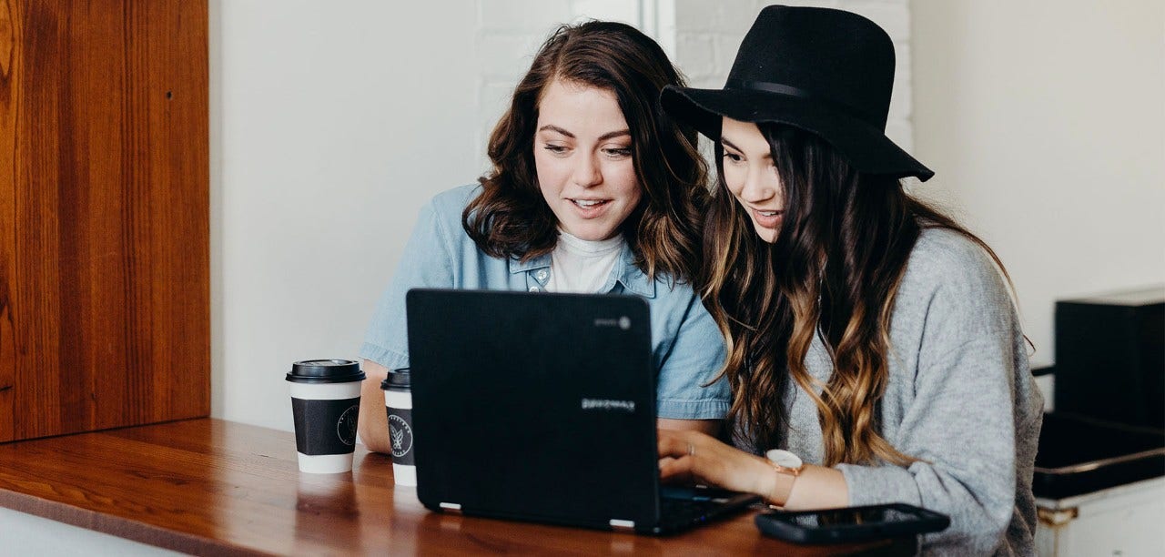 two women looking at a laptop