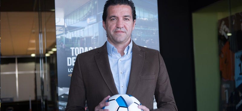 Man in a suit holding a football 