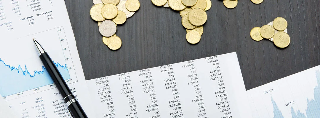 logistics tips coins arranged on a desk with a pen on it