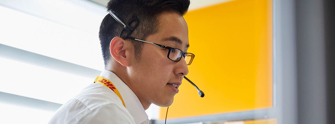 موظف DHL يرتدي سماعة رأس يتحدث