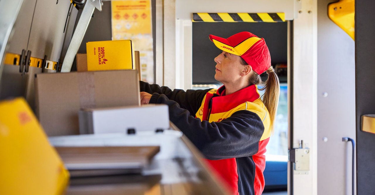  DHL employee is preparing parcels inside a delivery van