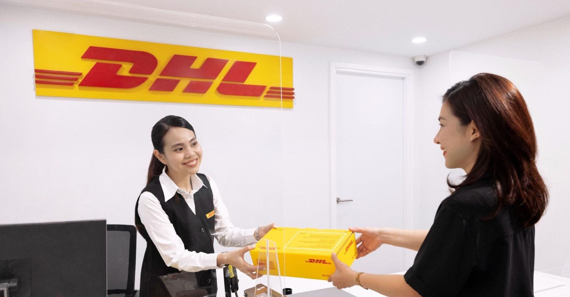 DHL Express employee receiving a parcel for shipping during holiday season