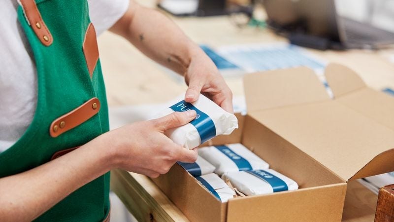 DHL Express 員工將可持續產品放入環保包裝的寄件箱內