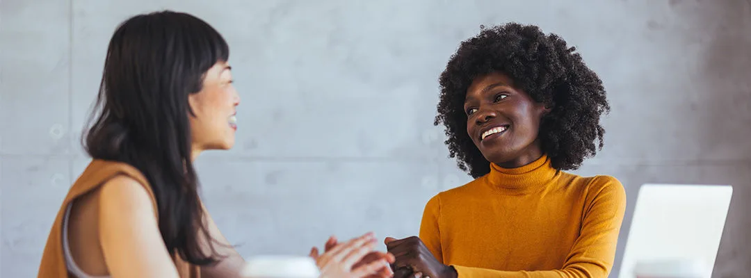 two women smiling at each other