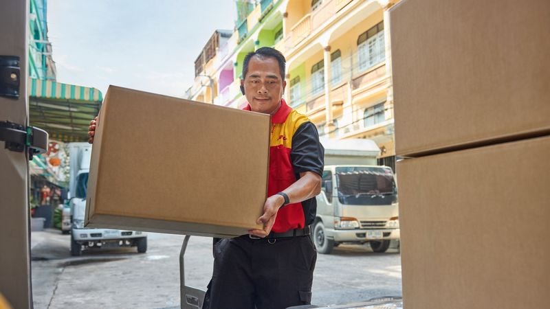 A DHL employee preparing a parcel as part of DHL’s international courier service