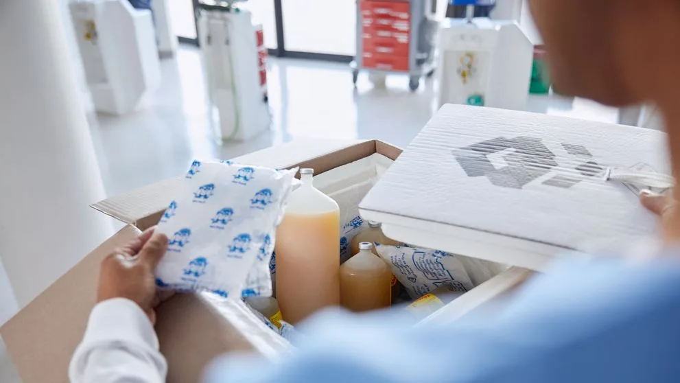 employee at a medical facility handling a new package of medical supplies