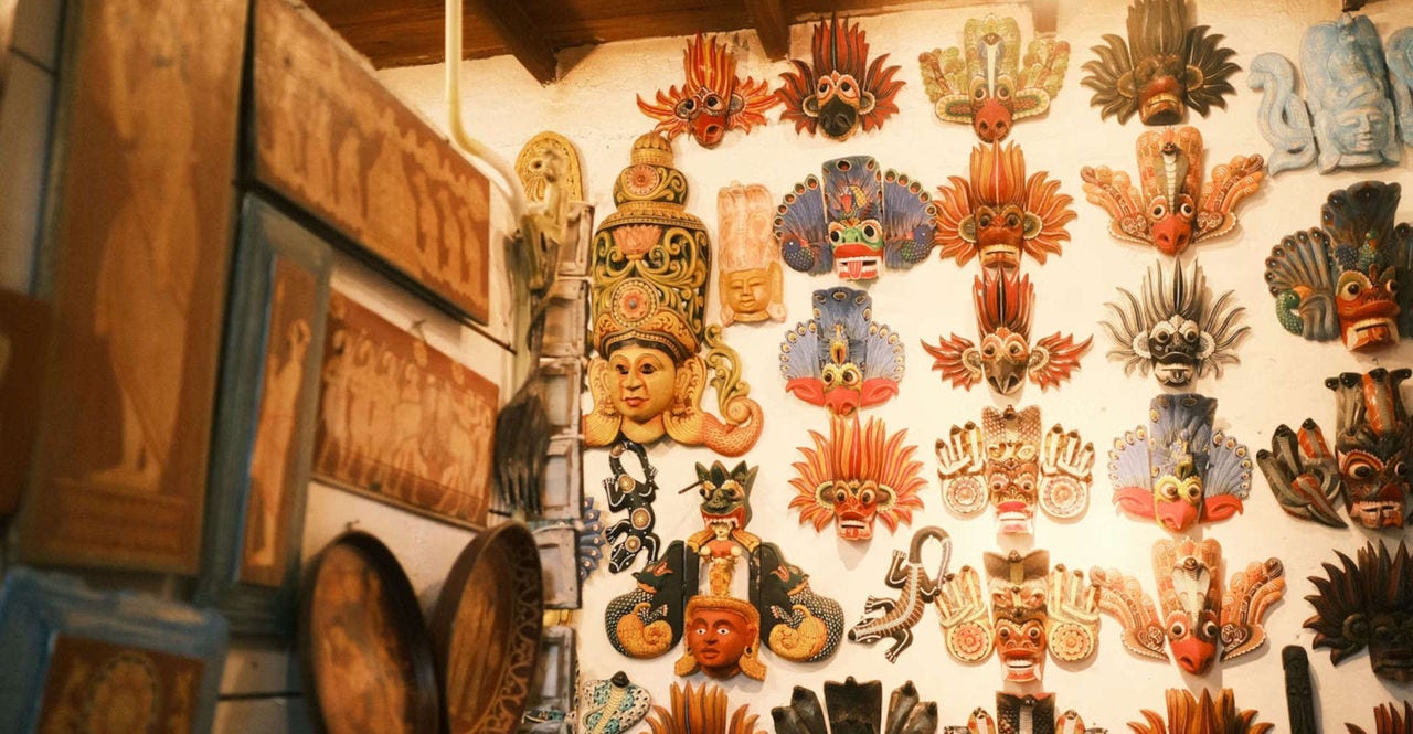 traditional Sri Lankan masks hanging from a wall