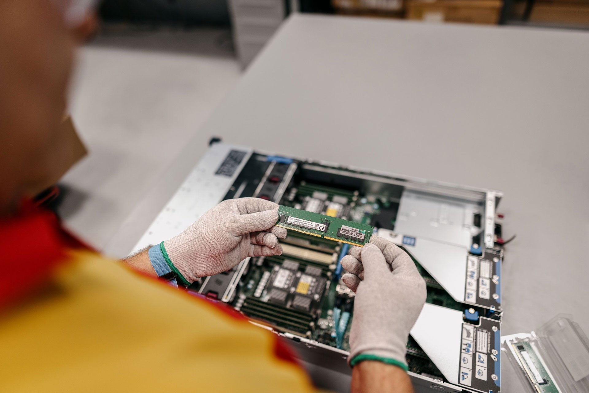 DHL employee wearing static gloves for safety and inserting replacement memory card