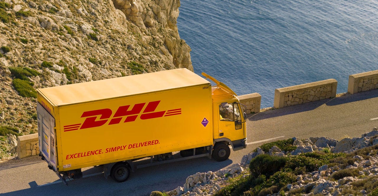 a DHL Express truck carrying a shipment of large items en route to its delivery location