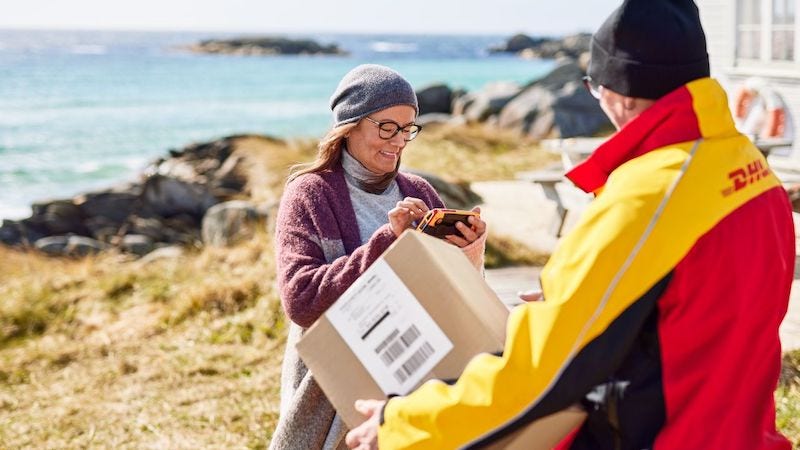 A DHL courier delivers a shipment to a customer