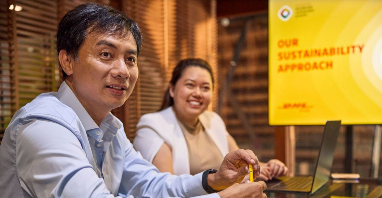 business owner in Thailand studying DHL Express’s sustainable shipping services