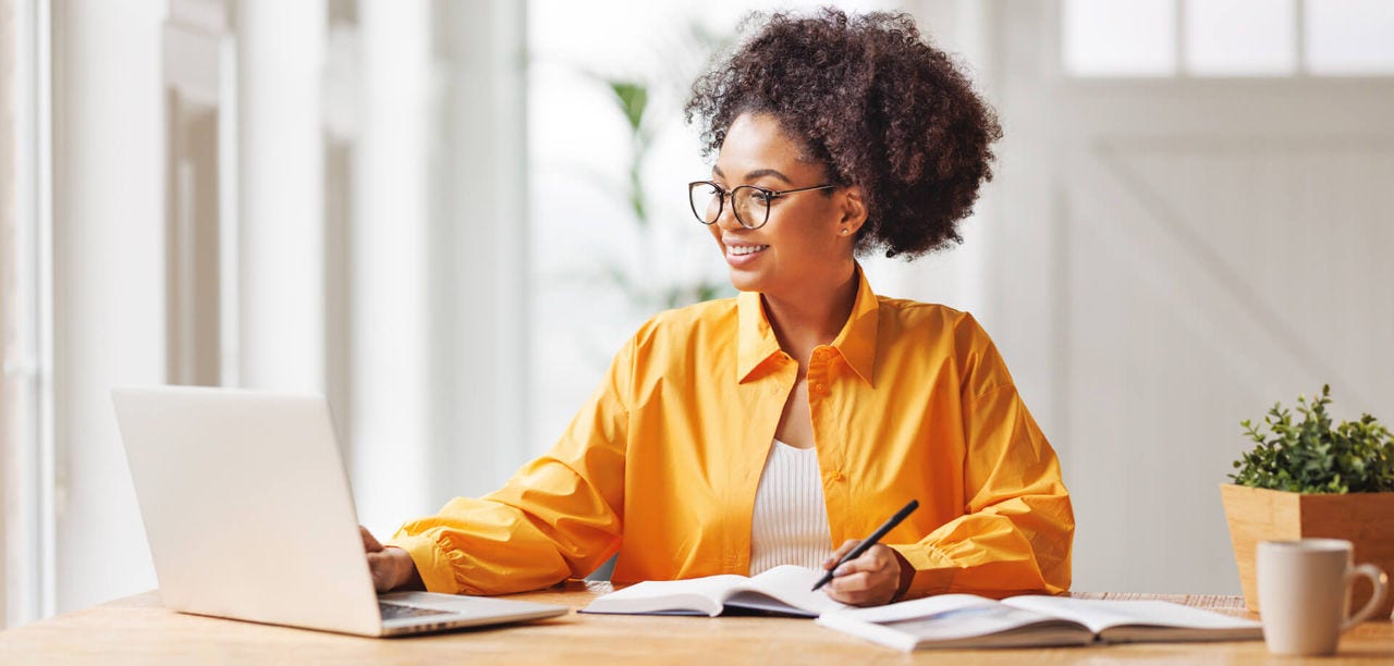 Woman on her laptop, taking notes 