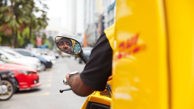 พนักงาน DHL Express กําลังจัดส่งด้วยสกู๊ตเตอร์
