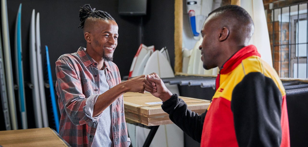 A DHL courier greets a small business owner 