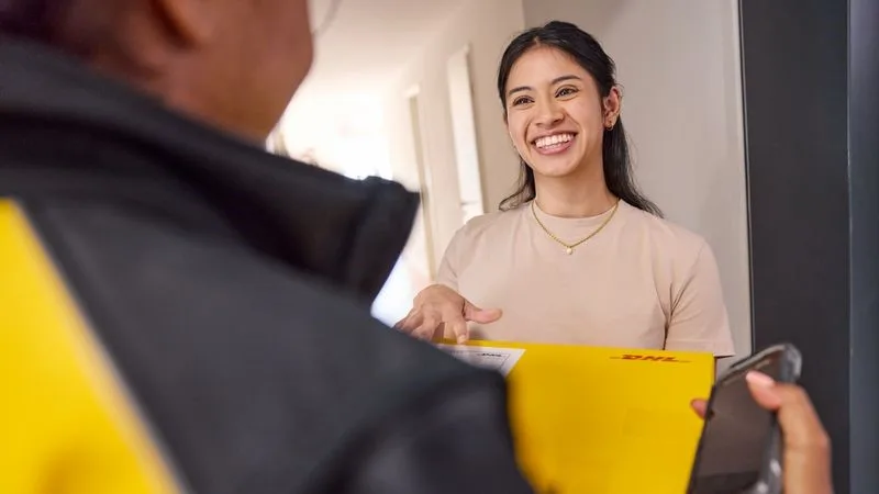 一名DHL Express速遞員把寵物食品物流包裹交付給一個女人。