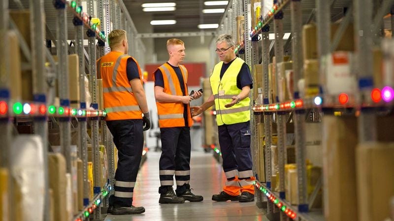 Three warehouse employees handling international food logistics operations