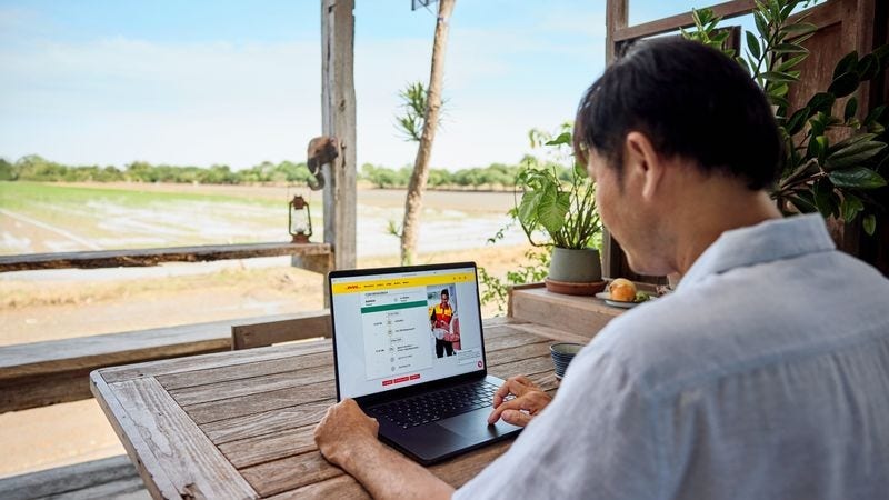 A man explores online shipping options from Sri Lanka on his laptop through the DHL Express website.