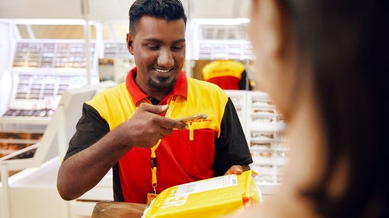 dhl express employee scanning a package from a customer for delivery