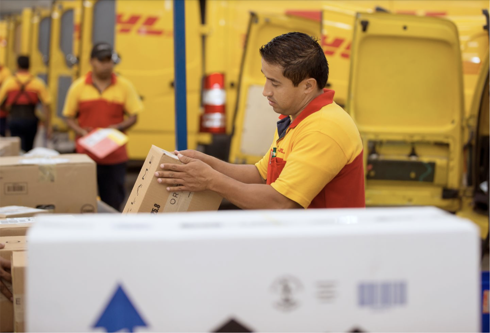 A DHL Express employee checking shipping details on a parcel