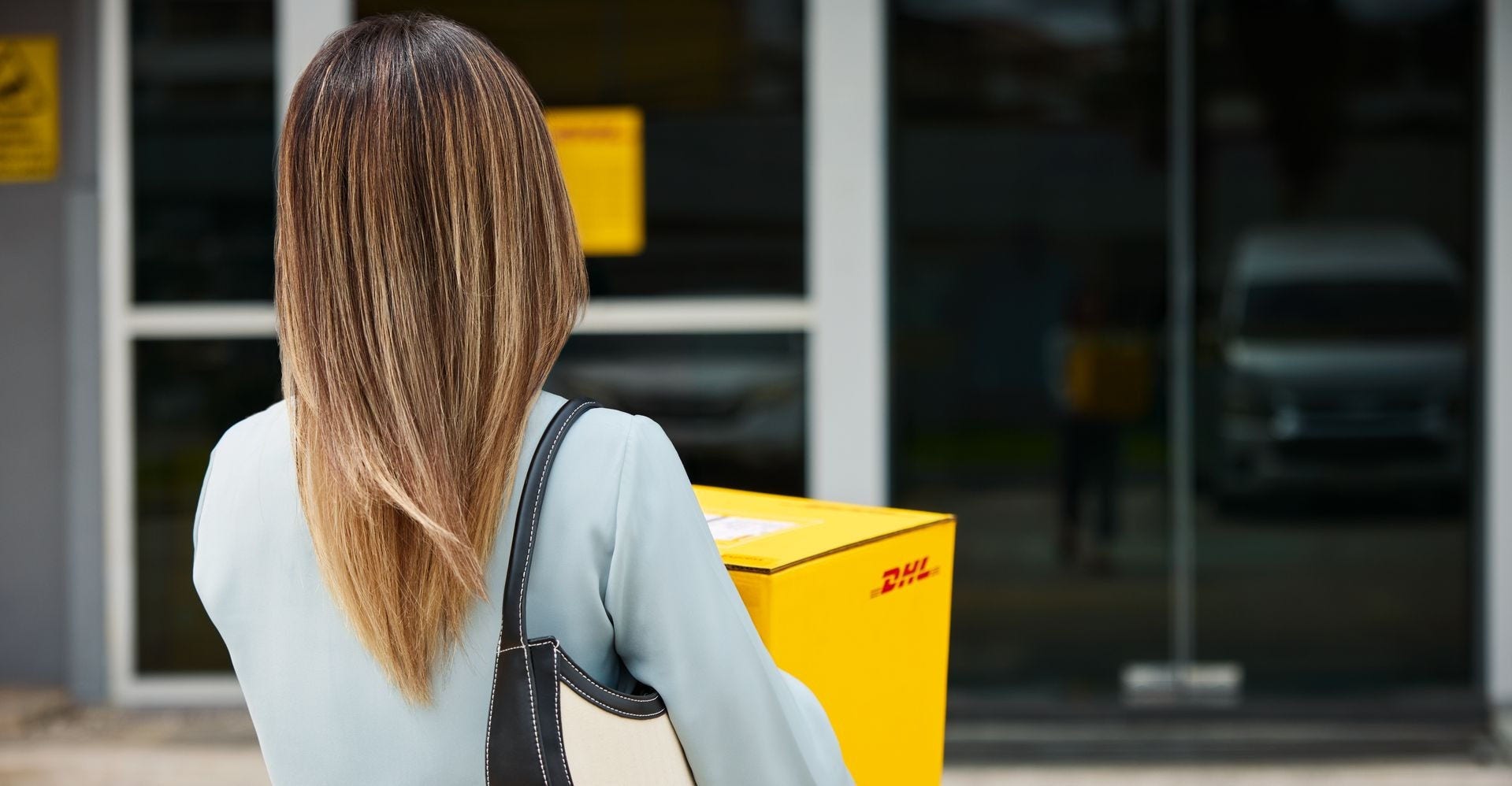 A New Zealand business owner bringing a package to a DHL Express service point to send to the UAE