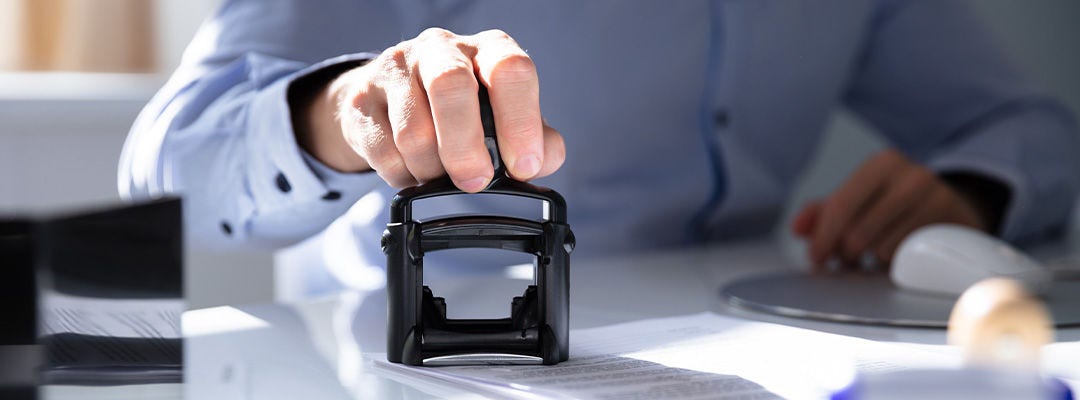 hand stamping on a paper with a metal stamp