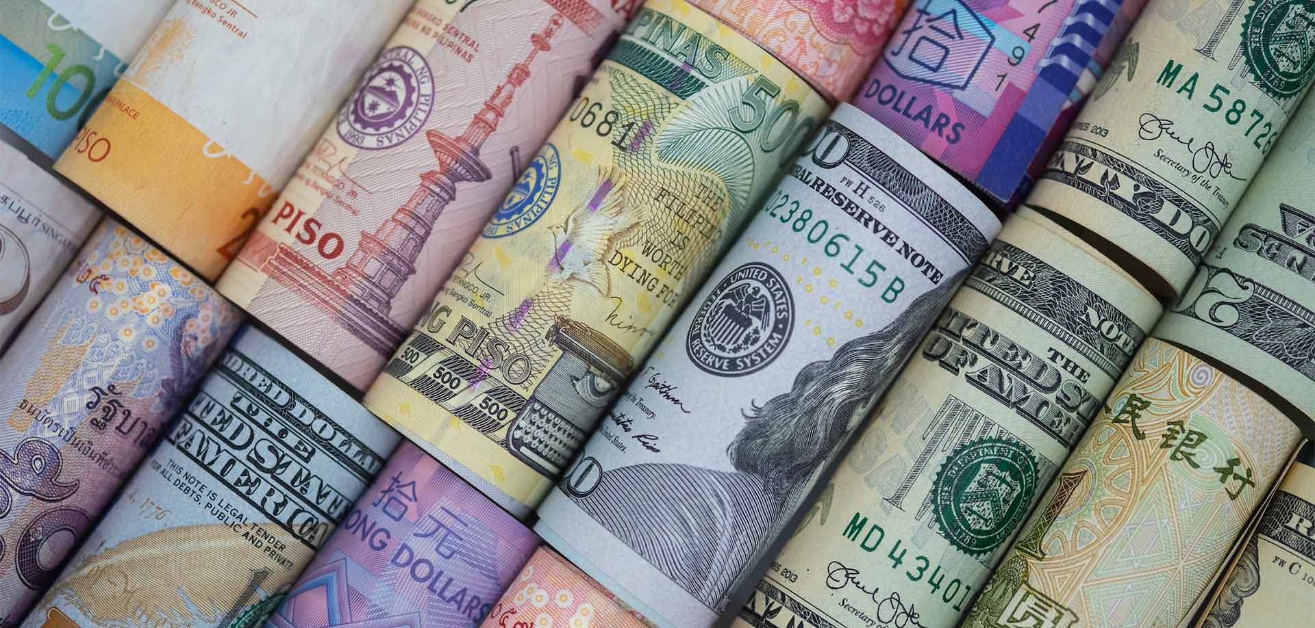 Gros plan roulé de billets variés à travers le monde. Concept de taux de change et d’investissement Forex. -Image.