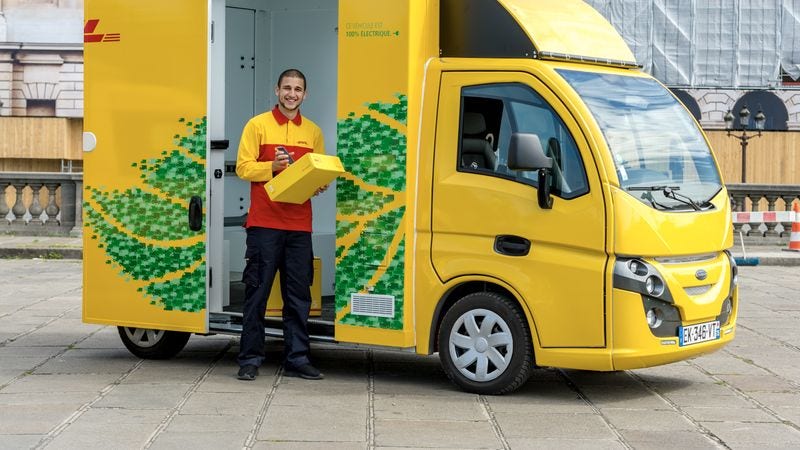 Van ekologis DHL Express di jalan, mempromosikan praktik bisnis berkelanjutan dengan solusi transportasi ramah lingkungan