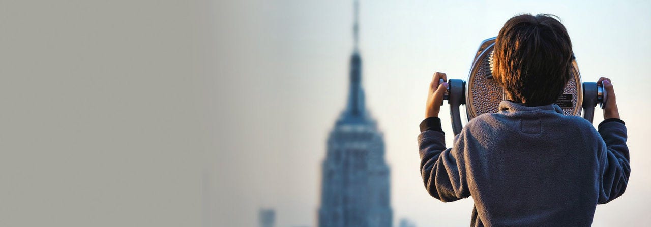 Boy looking at a cityscape through a telescope