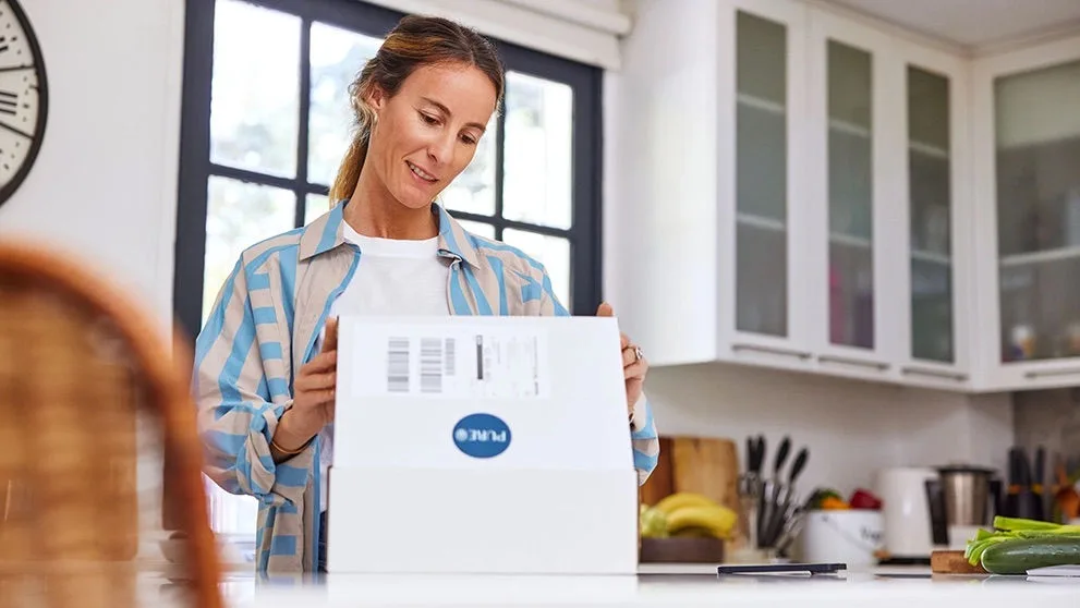 Woman opening at home the box of an international order bought on Black Friday