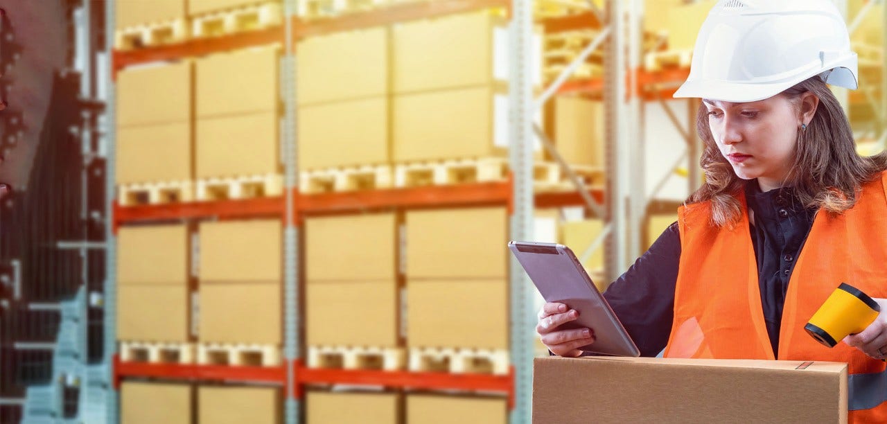 woman in warehouse looking at tablet screen