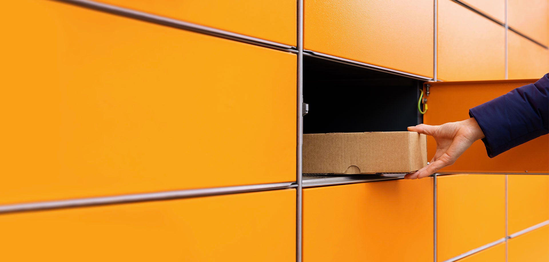 hand placing packaging in returns locker