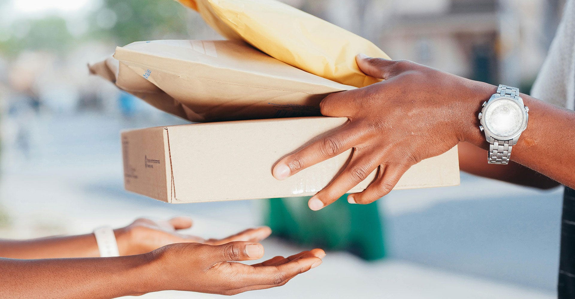A stack of tracked and insured parcels changes hands for shipping.