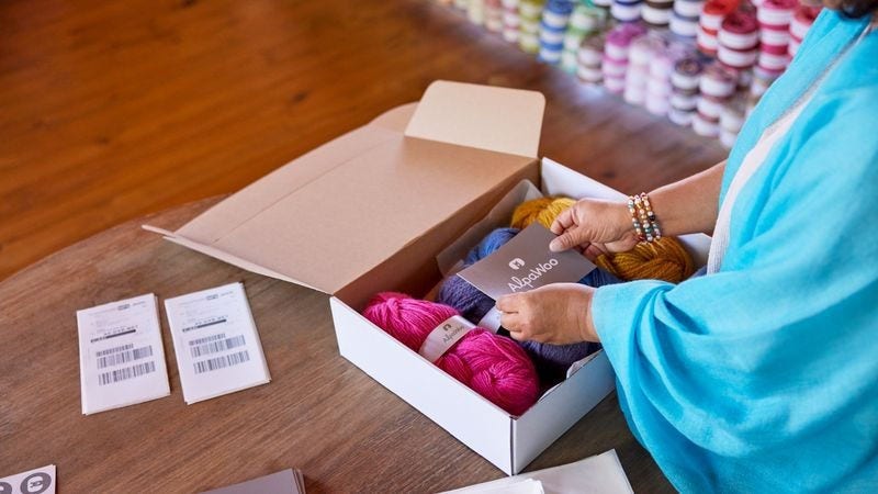 a business owner adding a logo to her product packaging to build a strong brand identity