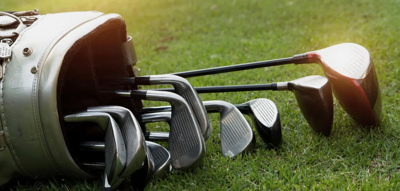 golf bag laid on its size with golf clubs sliding out