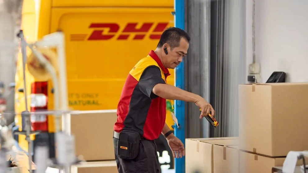 dhl express worker handling consolidated shipments with mid code